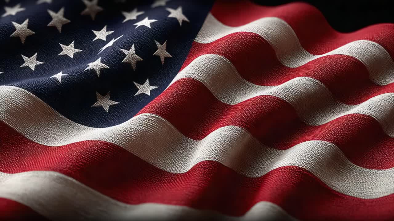Viftende amerikansk flagg som stolt viser sine stjerner og striper, symboliserer nasjonal stolthet, enhet og frihet mot en dristig svart bakgrunn.