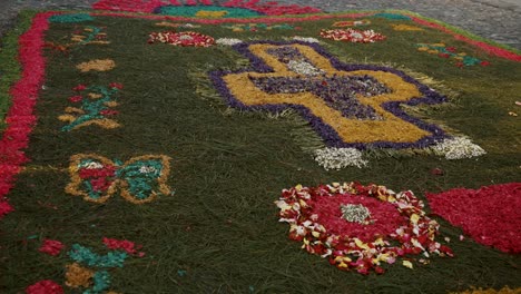 una alfombra de flores y agujas de pino decora la calle de antigua durante la semana santa en guatemala