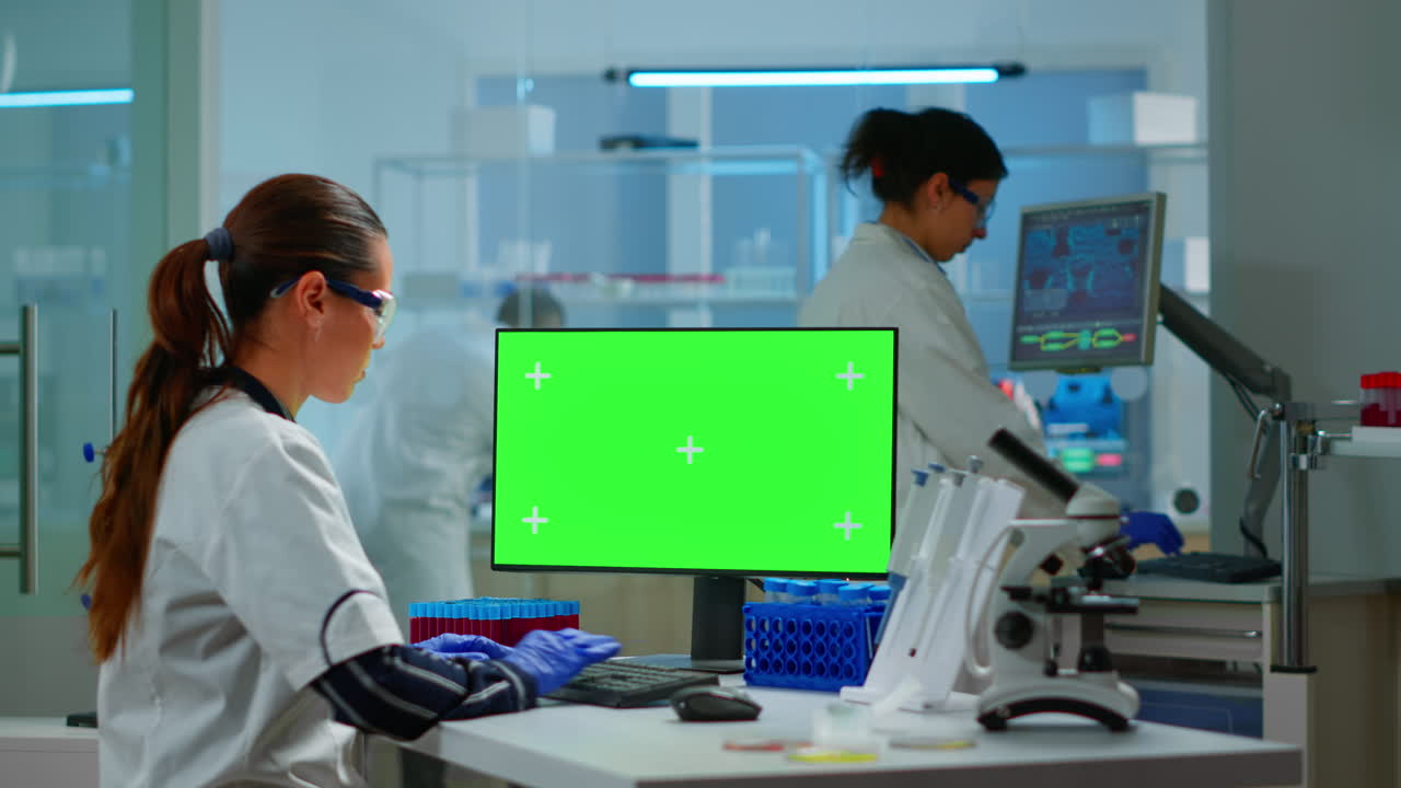 científico de investigación médica trabajando en una pc con pantalla verde