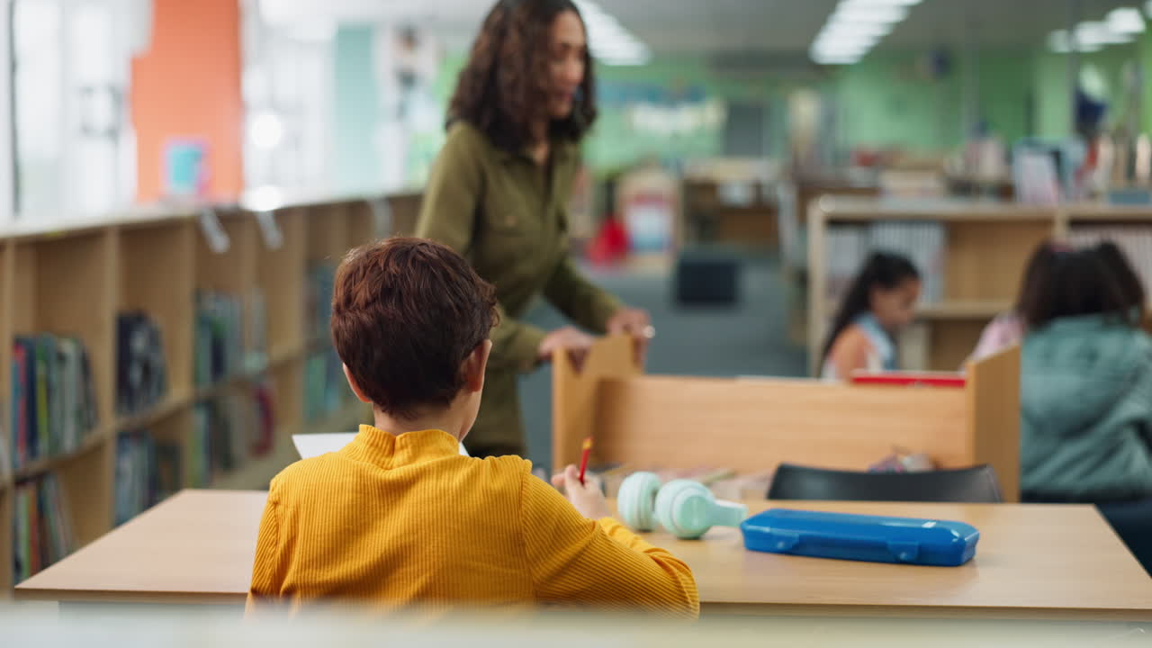 A child receives a book from their teacher in a library