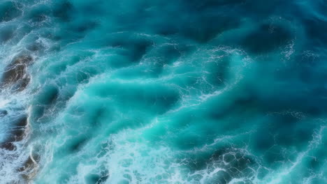 aerial view of turquoise ocean waves and foaming water