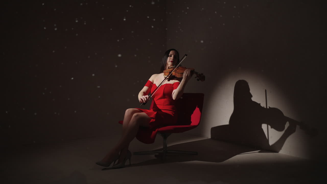 mujer tocando el violín en vestido rojo