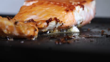 filete de salmón cocinado en grasa en sartén caliente, vista de cámara de cierre bajo