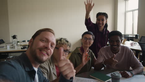 diverse group of colleagues taking a selfie during an office meeting
