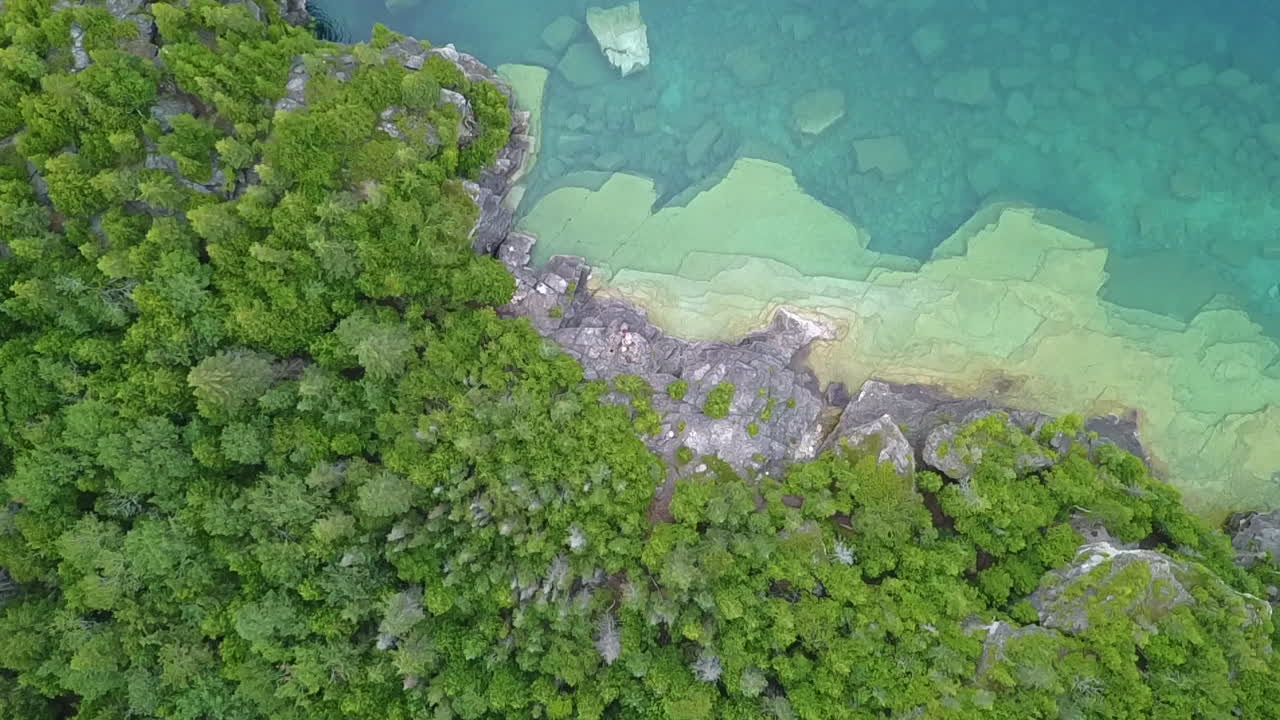 la antena desciende al acantilado rocoso, agua clara del lago huron de la bahía georgiana