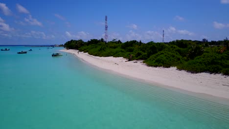 沿著熱帶島<unk>的海岸線的空中拍攝, 白色的沙灘上有棕<unk>樹