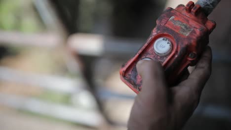 presionando el botón de elevación oxidado hacia abajo