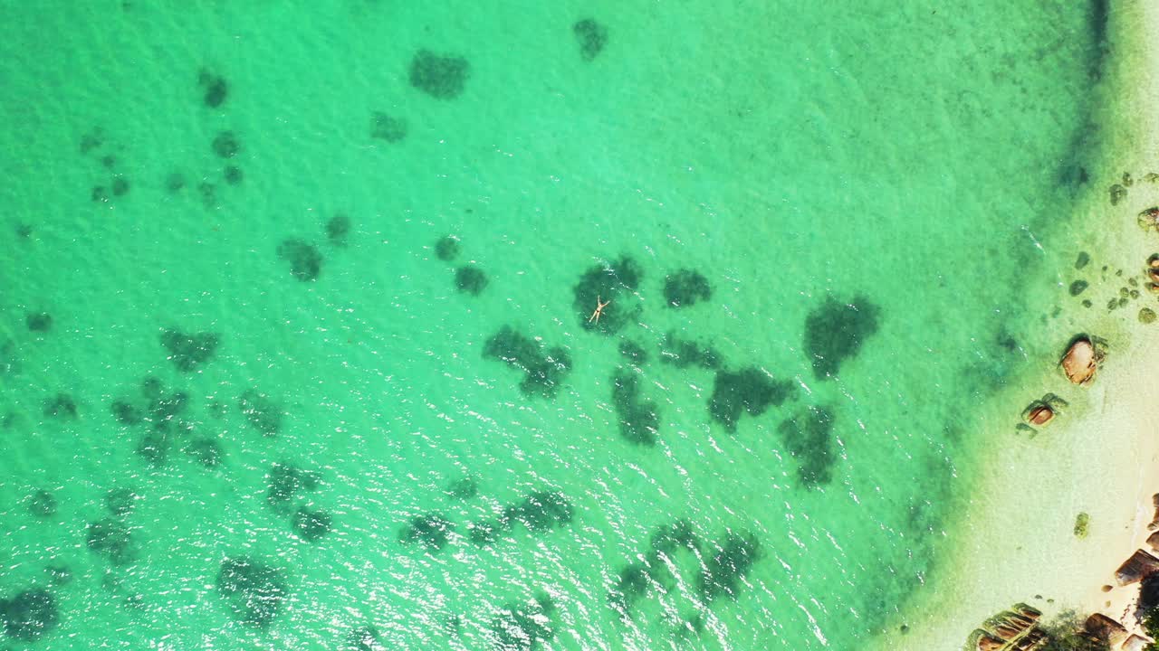 피지에 있는 열대 섬의 바위가 많은 해안선 근처 산호초 위에 청록색 잔잔한 석호 물이 있는 다채로운 바다 질감