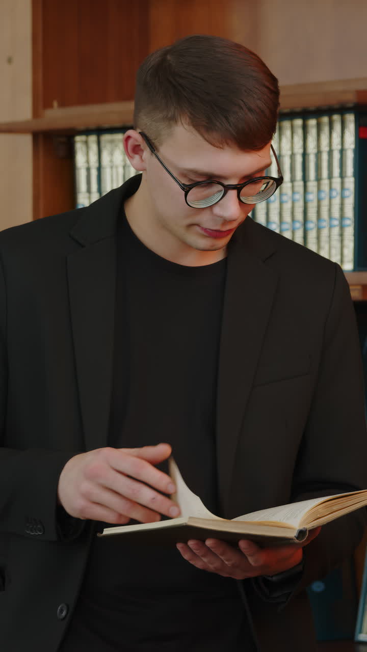 un joven leyendo un libro en una biblioteca
