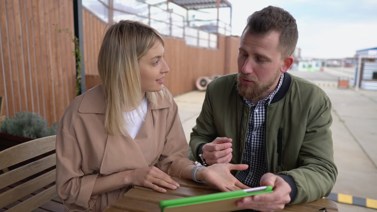 pareja discutiendo en un café al aire libre