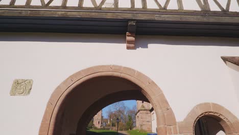 Große-Gebäudewände-Und-Tor-Mit-Blick-Auf-Mittelalterliche-Kirchenruinen-Im-Dorf,-Entdeckt-In-Baden-Baden-In-4k