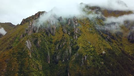 aerial, drone shot of low clouds on rocky andes mountains, on a cloudy day, near cusco, in peru, south america