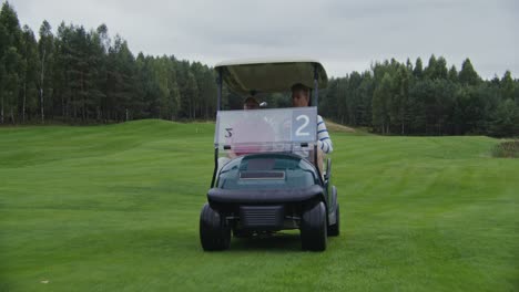 two men in a golf cart on a golf course