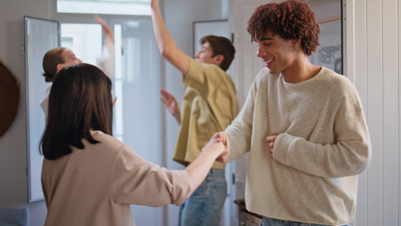 Dancing teenagers enjoy discotheque at home party. Overjoyed friends having fun