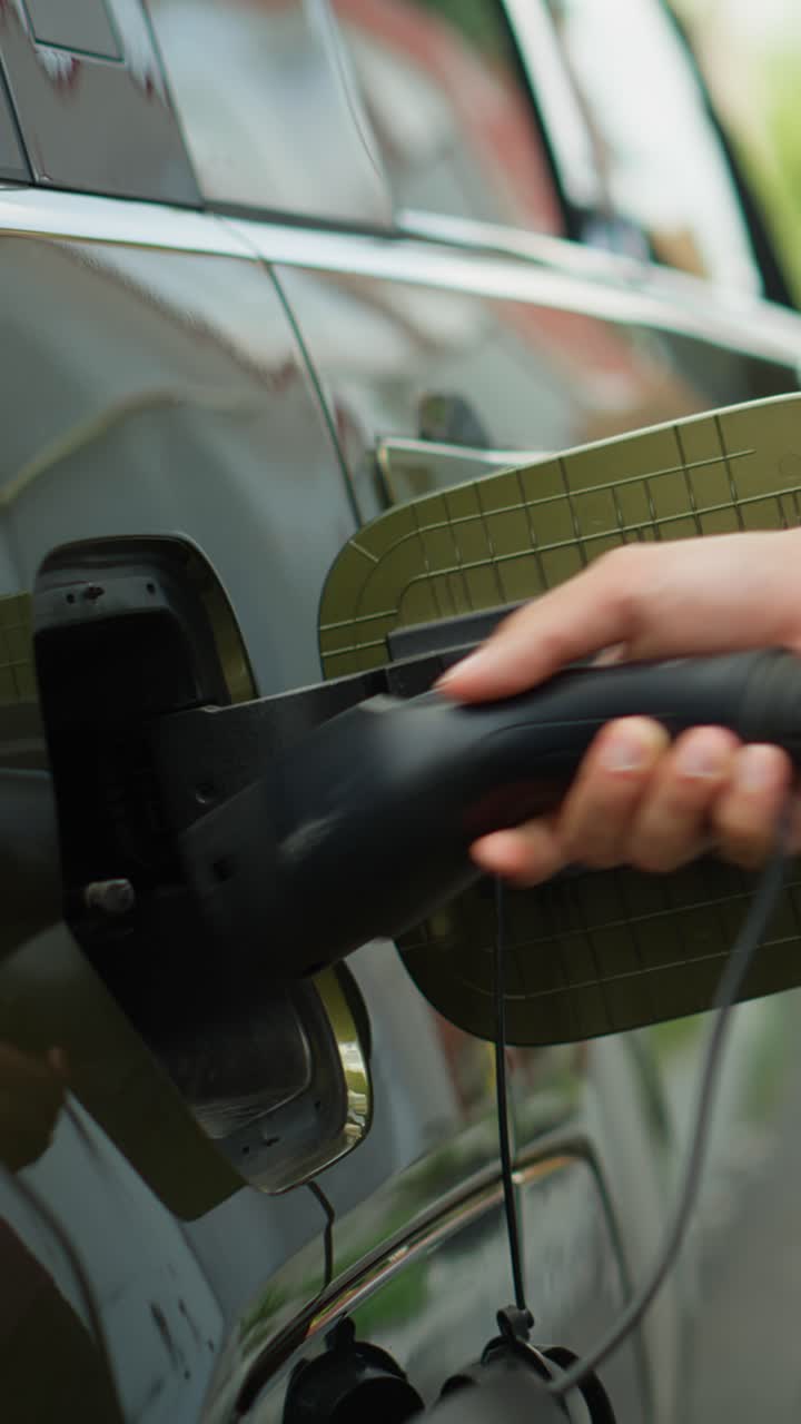 Vertical video Close up of person opening vehicle inlet port to charge electric automobile