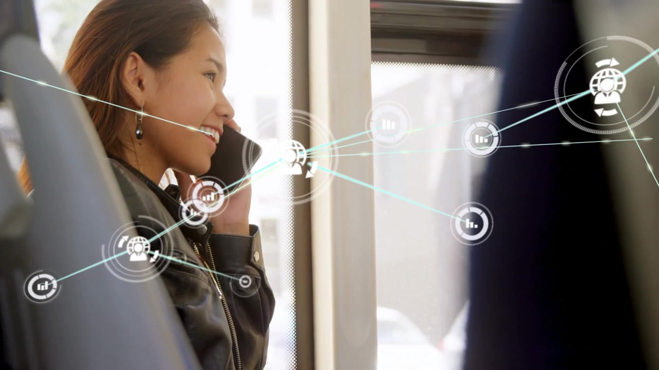 公共交通機関に乗車中、スマートフォンで話す若い女性。