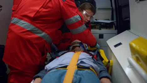 mixed race paramedics taking care about patient in emergency vehicle