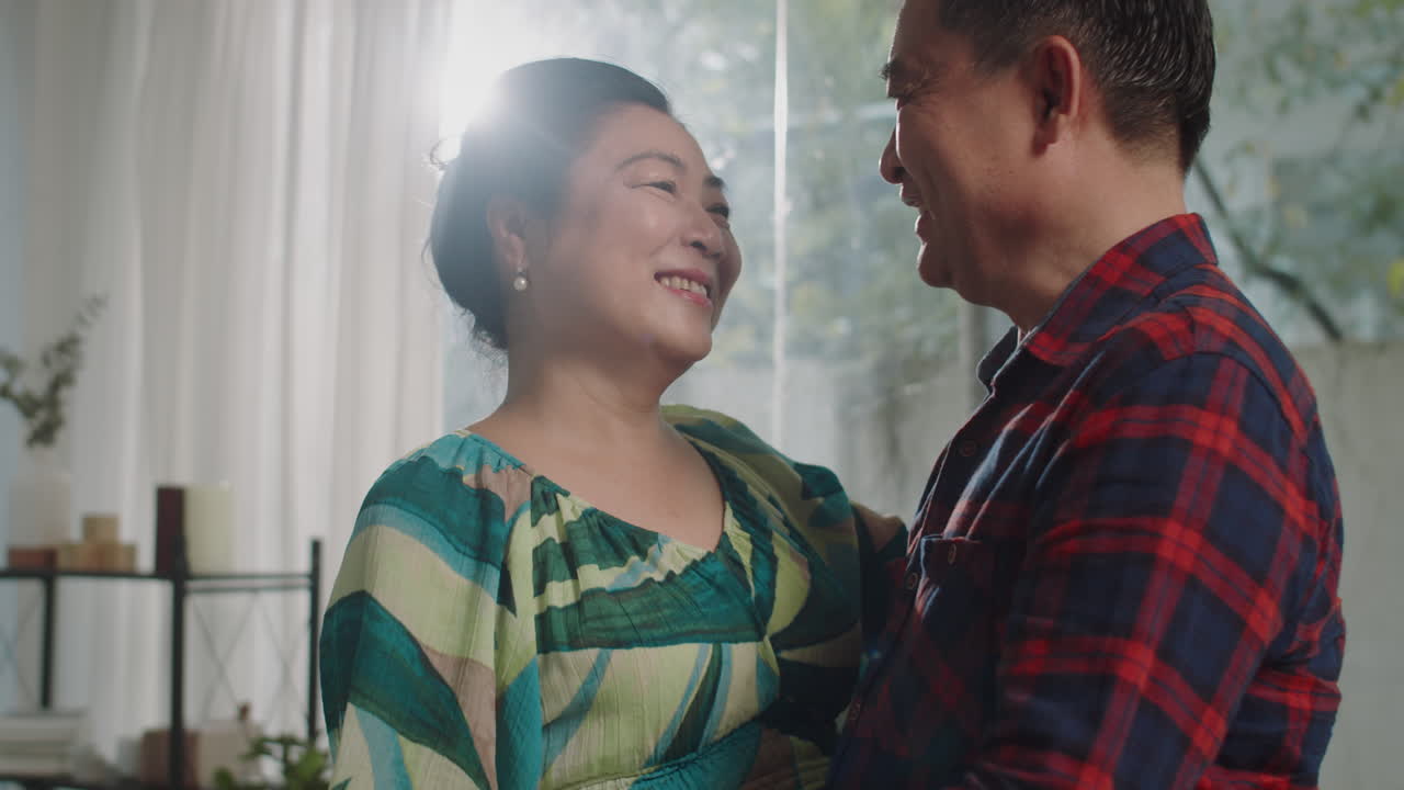 Affectionate Senior Spouses Singing and Dancing at Home