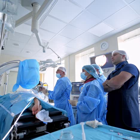 view from the side on experienced surgeons with medical tools during operation. health treatment concept