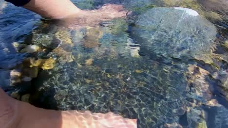 girl relaxing her feet in mountain river clear water at day