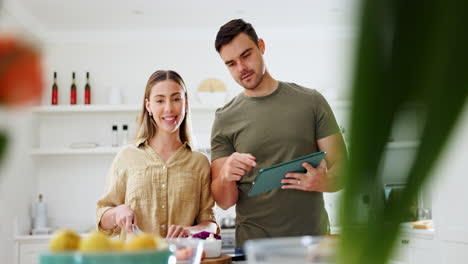 tableta, instrucciones y una pareja cocinando comida