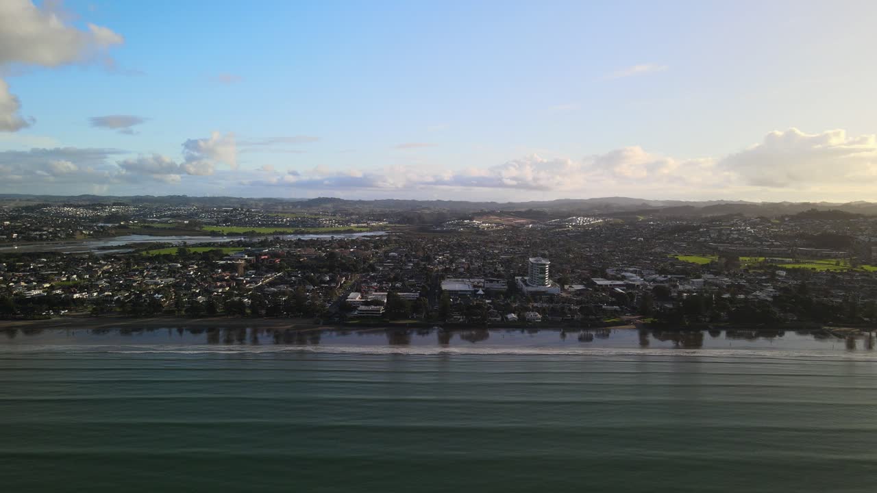volando de lado a lo largo de la costa de la playa de orewa