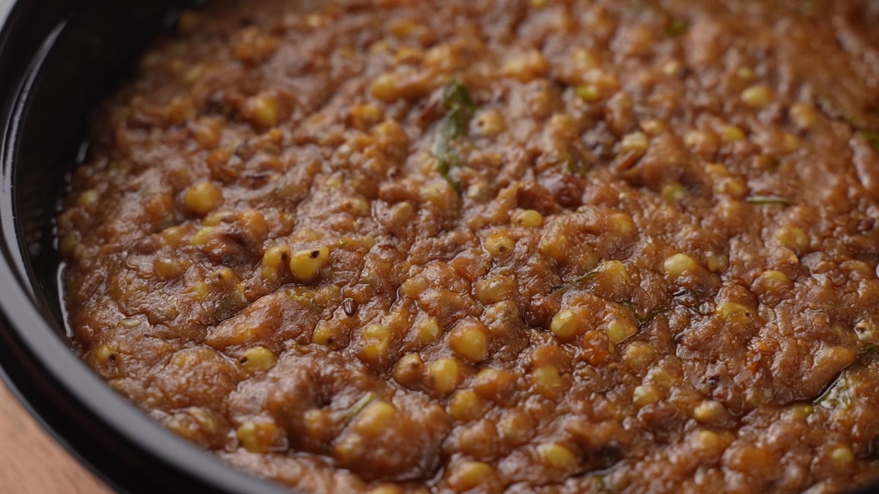 Khichdi di miglio sano appena cucinato servito caldo in una ciotola nera, ripresa ravvicinata di cibo