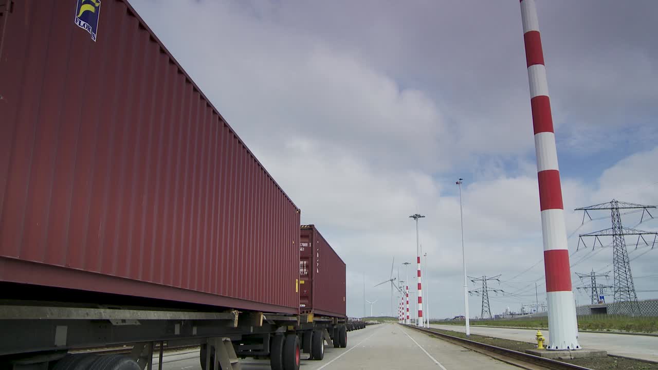 Rød fragtcontainer klar til eksport, logistiklastbil i havn, statisk vidvinkelbillede