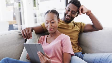 Feliz-Pareja-Afroamericana-Usando-Tableta-Y-Hablando-En-El-Sofá-En-Casa,-En-Cámara-Lenta