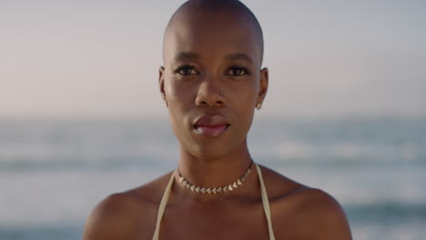 retrato de una atractiva joven mujer afroamericana que parece tranquila y pensativa disfrutando de una cálida playa soleada en cámara lenta