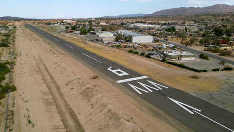 aerial drone shot showcasing runway at a small general aviation airport and surrounding area