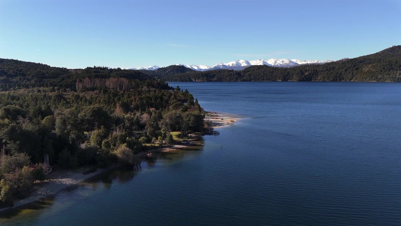 Descubra o deslumbrante Lago Perito Moreno e a encantadora Colônia Suíça na Patagônia, Argentina. Esta vista aérea deslumbrante exibe águas serenas, florestas exuberantes e uma vibrante herança cultural.
