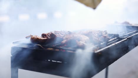 Toma-En-Cámara-Lenta-De-Un-Vendedor-Ambulante-Asiático-Cocinando-Ayam-Bakar-En-Una-Parrilla-Humeante