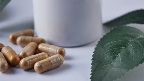 cápsula de medicina herbal que cae sobre el blanco