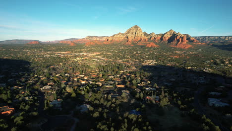 sedona arizona usa on sunny morning, drone shot of homes and houses in valley under red rock cliffs