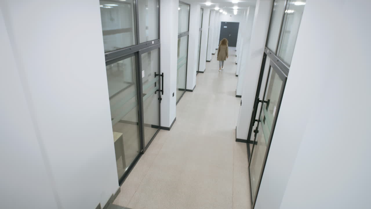 People Walking Through a Bright Modern Office Corridor
