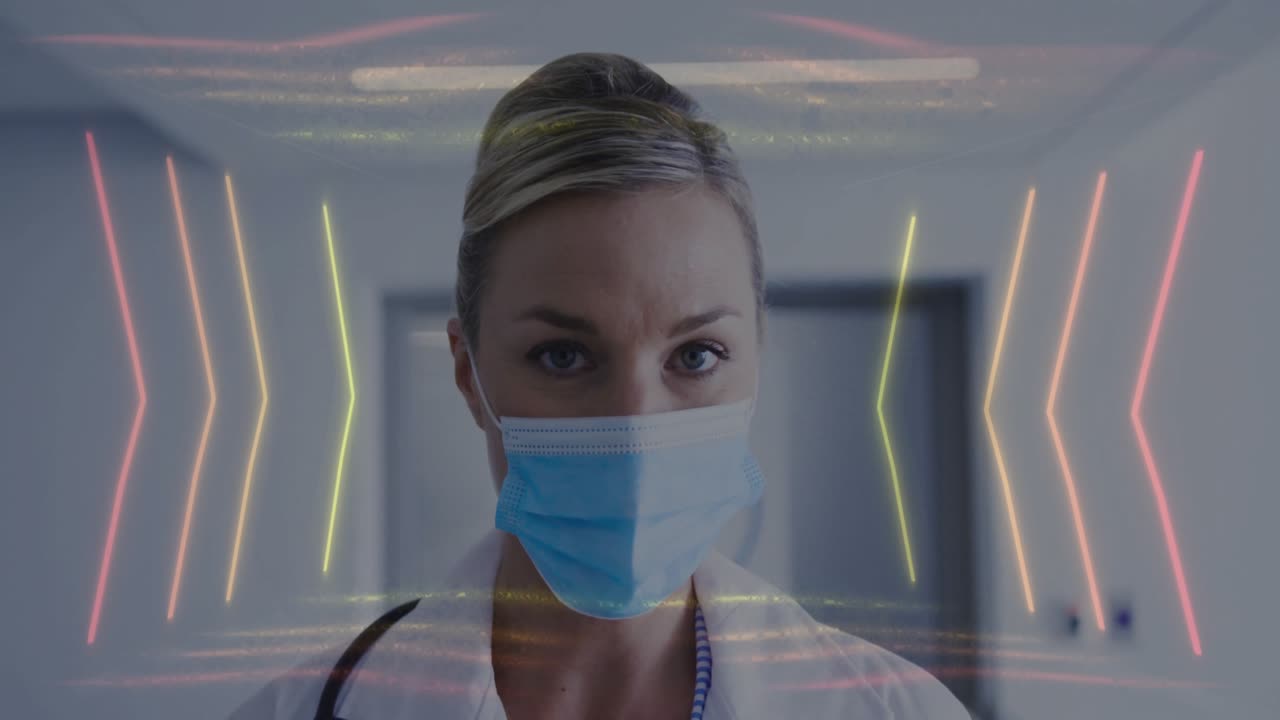 Dottoressa che indossa mascherina e camice da laboratorio di fronte alla telecamera, con un'interfaccia a freccia al neon.