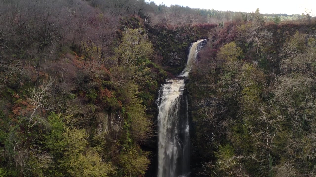 Le cascate di Glenashdale scendono impetuosamente attraverso una gola boschiva autunnale, Arran