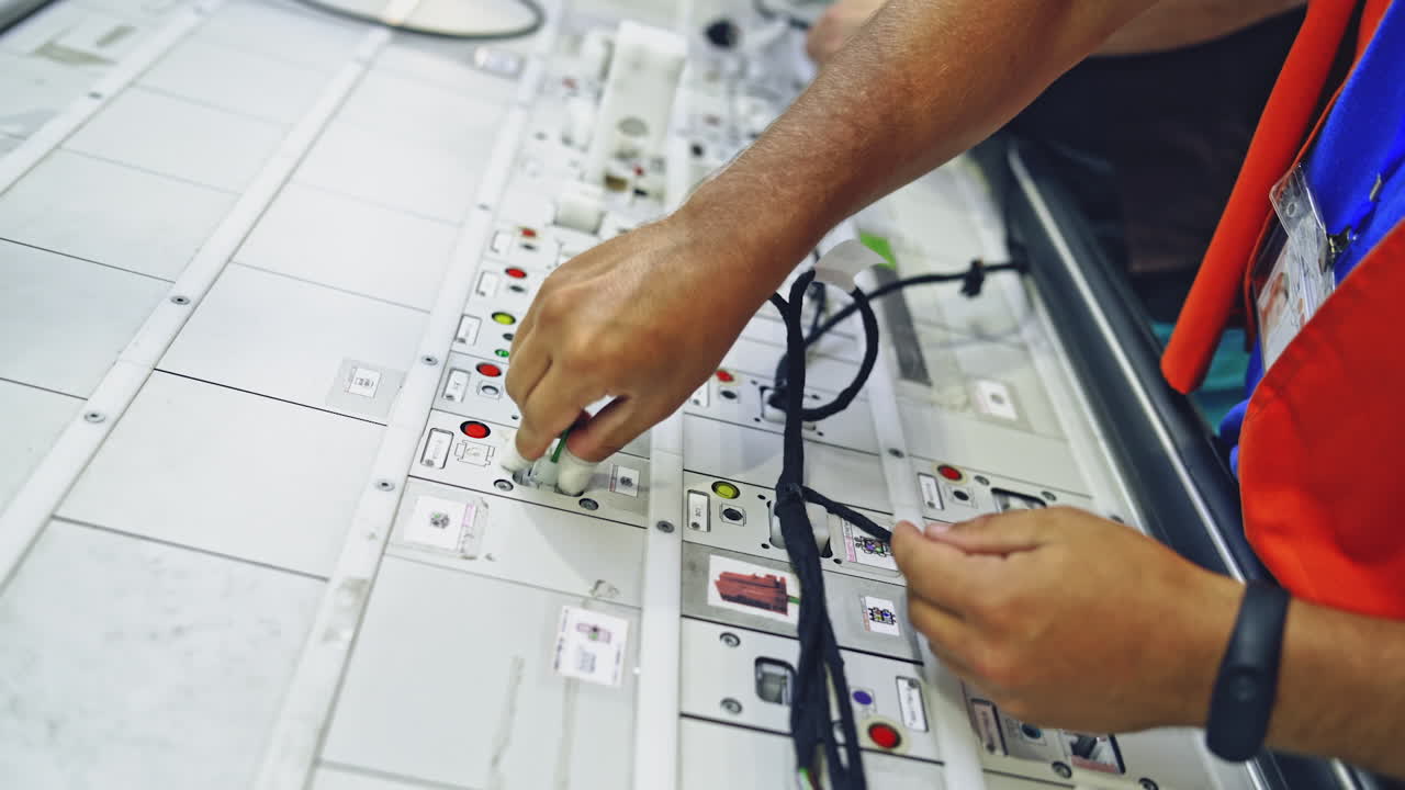 Hands employee during manufacture the wiring. Process of manufacturing the wiring harnesses for vehicles