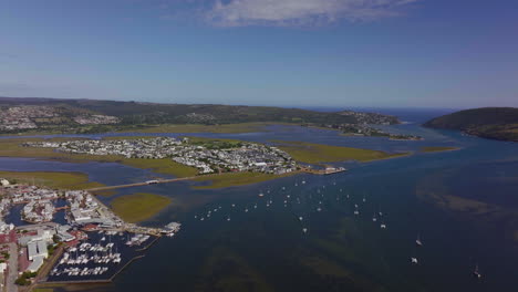 South-Africa-Garden-Route-sailboats-marina-beach-holiday-vacation-town-aerial-drone-cinematic-drive-toward-Still-Bay-George-Jeffreys-Bay-stunning-beautiful-late-afternoon-sunny-Africa-left-movement