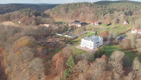 Große-Weiße-Herrenhausantenne,-Villa-In-Hügeliger-Landschaft-An-Sonnigen-Tagen