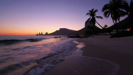 serene tropical beach sunset with mountains and palm trees