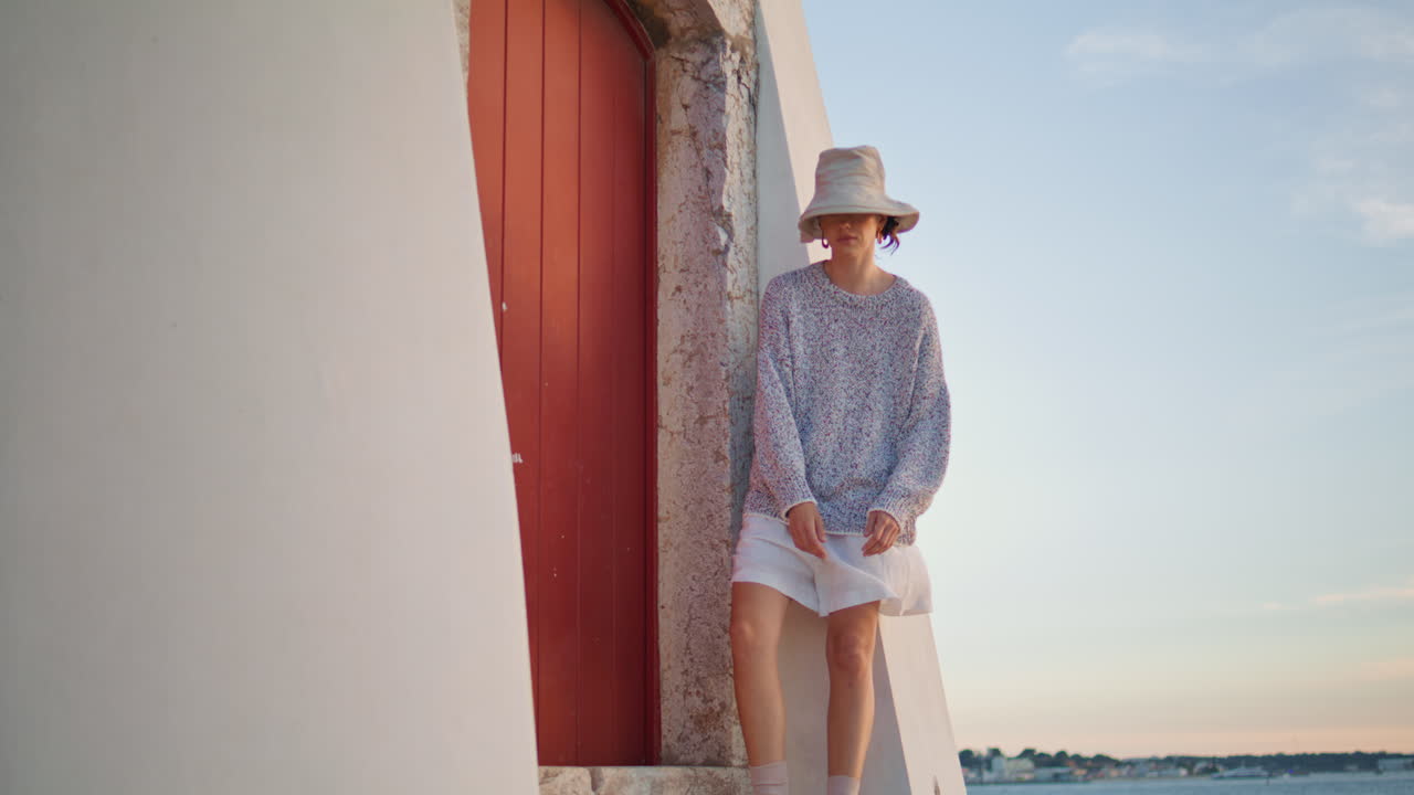 저녁에 여자가 강집에서 휴식을 취하고 있습니다. 야외에서 포즈를 취하는 캐주얼 여행자.