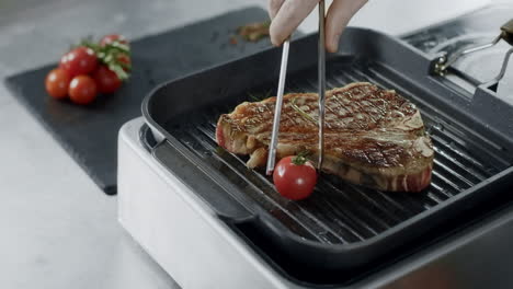 chef cocinando bistec a la parrilla en la sartén