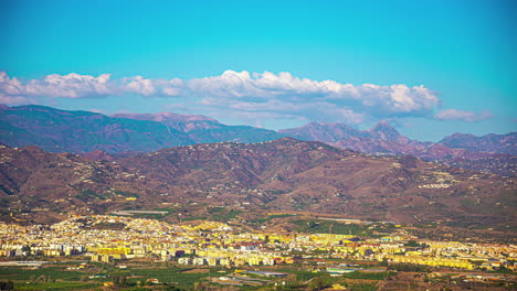 a still time lapse shot of a cityscape near a mountain range under a wind shear