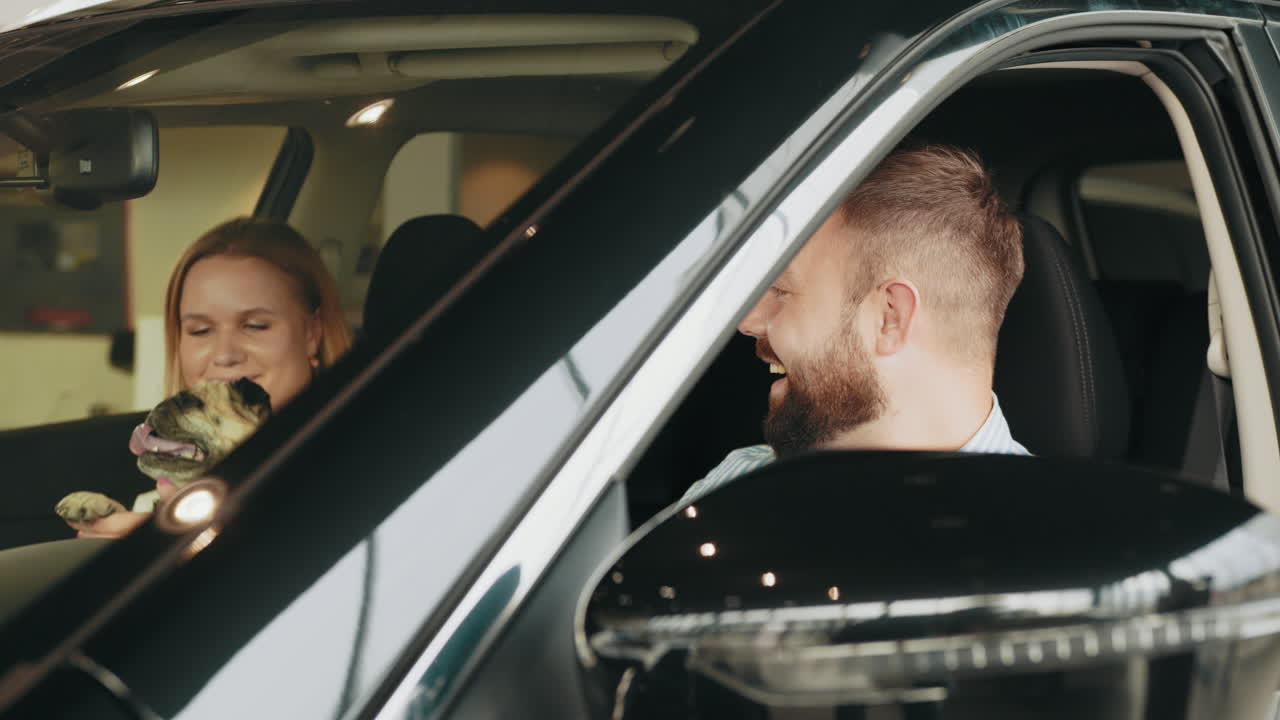 una pareja de prueba conduciendo un coche con su pug