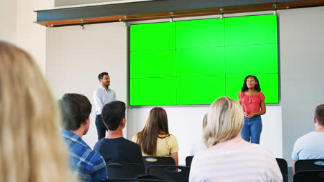 Female-Student-Giving-Presentation-To-High-School-Class-In-Front-Of-Screen