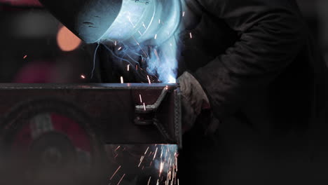 Welder-Welding-Joint-Of-A-Metal-Bar-In-A-Steel-Factory---close-up,-slow-motion