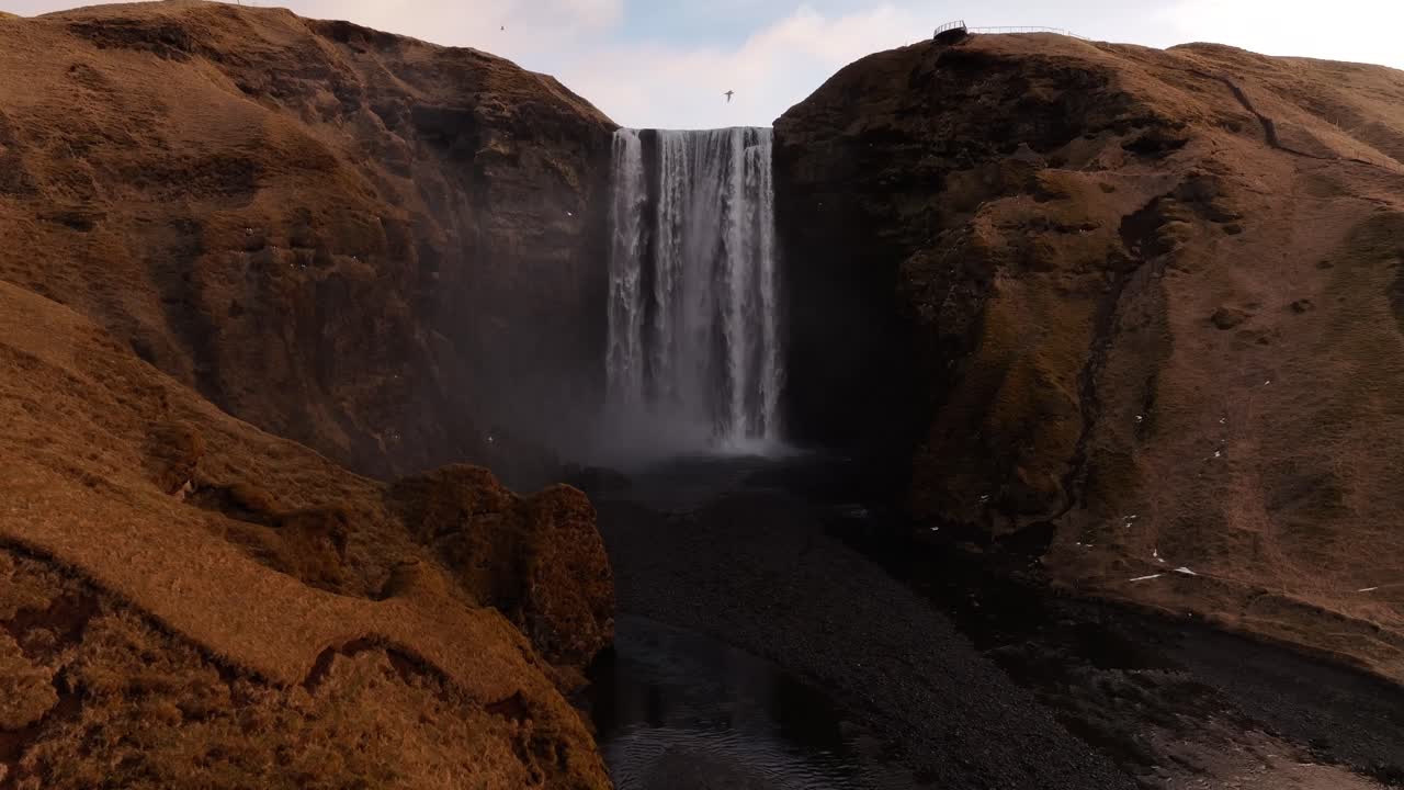 Waterfall Skógafoss in Skógar, Iceland, with river Skógá and Eyjafjallajökull in the background
