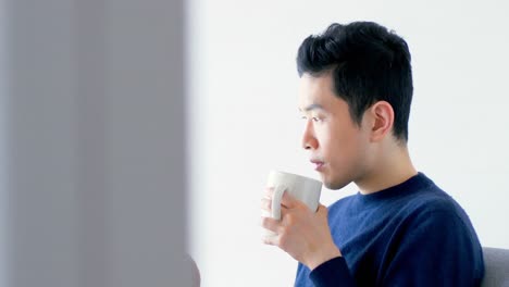 man using digital tablet while having cup of coffee 4k